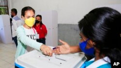 A woman casts her ballot at a polling station during the presidential election in Dili, East Timor, March 19, 2022.