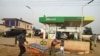 A vendor pushes wheelbarrow past a filling station dispensing diesel to motorists at Warewa, along Lagos Ibadan expressway, Ogun State, southwest Nigeria, on March 14, 2022.