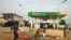 A vendor pushes wheelbarrow past a filling station dispensing diesel to motorists at Warewa, along Lagos Ibadan expressway, Ogun State, southwest Nigeria, on March 14, 2022.