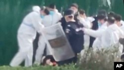 据目击者和社交媒体上的视频称，郑州全球最大的苹果手机工厂的员工在反病毒控制和工资抗纠纷的议活动中遭到殴打和拘留。 (美联社照片）