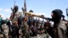 FILE - Armed al-Shabab fighters ride on pickup trucks as they prepare to travel into Mogadishu, Somalia, Dec. 8, 2008. 