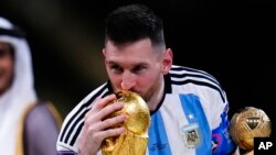 Lionel Messi dari Argentina mencium trofi setelah memenangkan pertandingan sepak bola final Piala Dunia antara Argentina dan Prancis di Stadion Lusail di Lusail, Qatar, Minggu, 18 Desember 2022. (Foto: AP/Manu Fernandez)