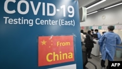 韩国仁川国际机场的医护人员为从中国抵达的乘客进行核酸检测。（2023年1月3日）