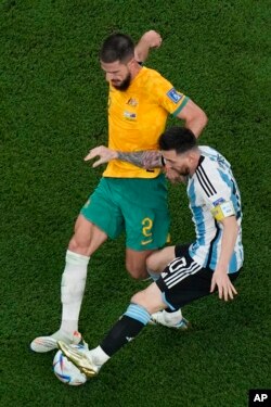 Argentina's Lionel Messi, right, and Australia's Milos Degenek battle for the ball during the World Cup round of 16 soccer match between Argentina and Australia at the Ahmad Bin Ali Stadium in Doha, Qatar, Dec. 3, 2022.