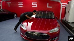 资料照：北京特斯拉电动车专卖店的工作人员在为特斯拉首批销售做准备。（2018年10月17日）
