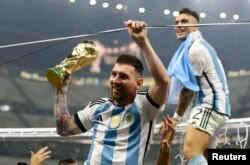 Lionel Messi merayakan kemenangan Argentina di laga Piala Dunia saat pemain Argentina Lautaro Martinez duduk di bingkai gawang. (Foto: REUTERS/Hannah Mckay)