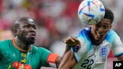 England's Jude Bellingham, right, struggles for the ball with Senegal's Kalidou Koulibaly during the World Cup round of 16 soccer match between England and Senegal, at the Al Bayt Stadium in Al Khor, Qatar, Dec. 4, 2022.