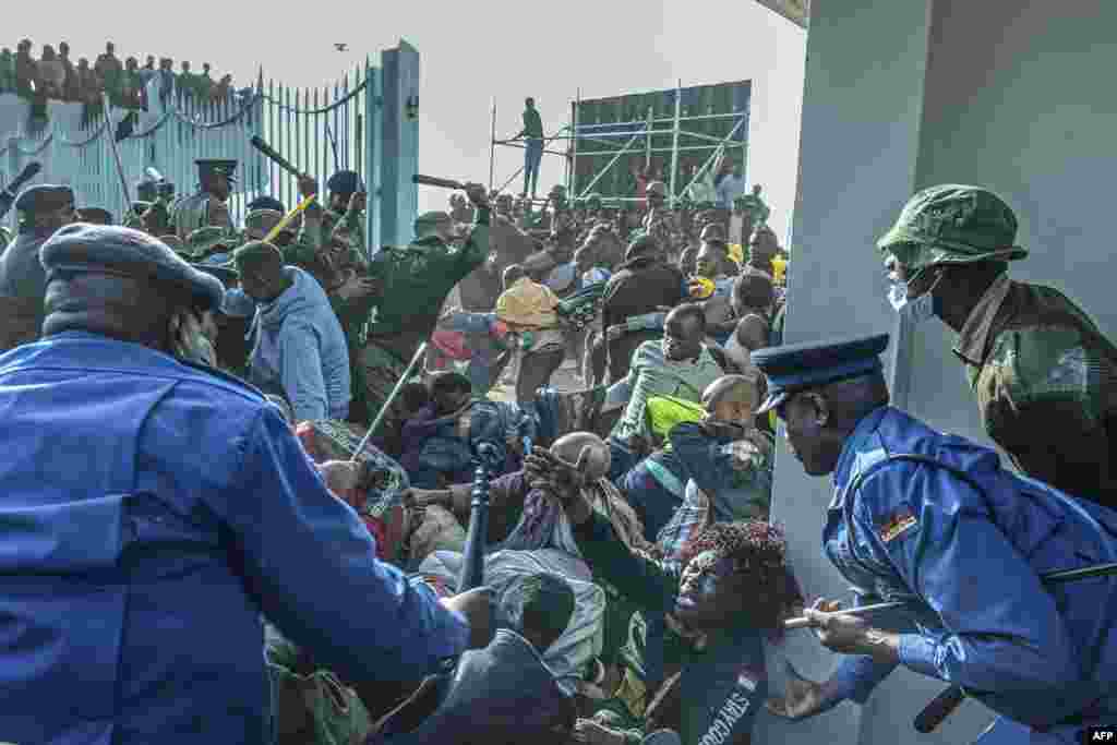 A woman (C) pleads for help as Kenyan security forces intervene during a stampede at the entrance of the Moi International Sports Center Kasarani in Nairobi, Kenya, Sept. 13, 2022, ahead of William Ruto inauguration ceremony.