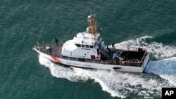 FILE - A U.S. Coast Guard vessel searches for survivors of a Puerto Rico National Guard helicopter crash, Dec. 22, 2010. The Coast Guard responded July 28, 2022, to a report of deaths related to a suspected human smuggling operation near Puerto Rico.