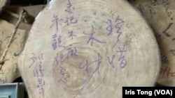 香港前商务及经济发展局局长邱腾华参观志记鎅木厂后签名留言“珍惜木材” (美国之音/汤惠芸)