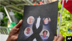 2022年7月26日，星期二，一名居住在泰国的缅甸人拿着被处决的政治犯的照片，他们在泰国曼谷的缅甸大使馆外抗议。国际社会对缅甸处决四名政治犯感到愤怒。