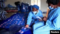 Para petugas tengah bekerja di pabrik pembalut yang dapat digunakan kembali di Bonda Women Craft Centre, di distrik Mutasa, di Mutare, Zimbabwe, 13 Juli 2022. (REUTERS/Philimon Bulawayo)