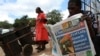 FILE - A man reads a copy of The Standard newspaper on the streets of Harare, Dec. 13, 2010.