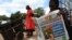 FILE - A man reads a copy of The Standard newspaper on the streets of Harare, Dec. 13, 2010.