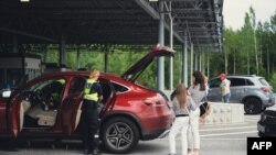 Митники перевіряють російські автомобілі 28 липня 2022 року на прикордонному переході Нуйямаа, Фінляндія. З 1-го вересня Фінляндія скоротила кількість віз, які видаються росіянам з 1 вересня. (Фото Алессандро РАМПАЦЦО / AFP)