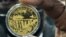 A Reserve Bank of Zimbabwe official displays the newly introduced gold coin in Harare, July 25, 2022. 