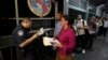 FILE - A U.S. Customs and Border Protection officer checks the documents of migrants who are on their way to apply for asylum in the United States, on International Bridge 1 as they depart Nuevo Laredo, Mexico, Sept. 17, 2019.