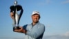 Charl Schwartzel of South Africa holds up the trophy for winning the inaugural LIV Golf Invitational at the Centurion Club in St. Albans, England, June 11, 2022.