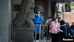 北京市民在一中国建设银行支行前排队等候进行新冠核酸检测。（2022年6月6日）