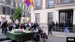 示威者把纸扎坦克摆在中国驻英大使馆外，并且把纸扎坦克的炮口指向大使馆。 （美国之音郑乐捷）