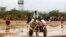 Newly arrived Somali refugees ride a donkey along the street at the Ifo Extension refugee camp in Dadaab, near the Kenya-Somalia border, October 19, 2011.
