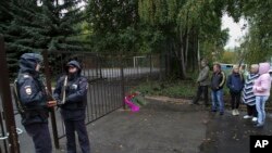 俄罗斯9月26日发生两起枪击案，其中一起发生在俄罗斯中西部乌德穆尔特共和国首府伊热夫斯克第88学校，图为枪击案现场有人献花，有人驻足表示哀悼。第88学校的枪击案造成13人死亡，其中有7名儿童，另外还有21人受伤。-美联社照片