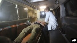 2016年8月24日阿富汗美国大学遭袭后救护人员抢救受伤人员。