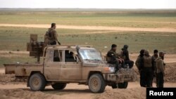 Members of Syrian Democratic Forces (SDF) stand together near Baghouz, Deir Al Zor province, Syria, Feb. 11, 2019. 