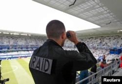 A member of France's rapid intervention police force RAID surveys spectators inside Bordeaux stadium, where Belgium was playing Ireland in Euro 2010 football competition, June 18, 2016.