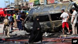 Warga dan petugas keamanan memeriksa lokasi kejadian ledakan bom di Basra, sebelah tenggara Baghdad (29/7).