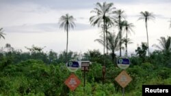 FILE - Signposts inform about the presence of a pipeline in a bush in Ughelli, Delta state, Nigeria, Sept. 16, 2020. Nigerian authorities confirmed Feb. 3, 2022, that an offshore oil production facility exploded in the region.