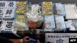 资料照片：2021年7月22日，在香港警方的新闻发布会上，媒体成员拍摄证据，包括试图解释香港民主运动的儿童书籍。此前，五人因出版这些书籍而被控煽动叛乱。