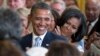 FILE - President Barack Obama and first lady Michelle Obama applaud during the portrait unveiling ceremony for former President George W. Bush and former first lady Laura Bush portraits, May 31, 2012, at the White House in Washington. 