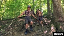 Pramuka putri dari Cub South Den 13, dari Pramuka Cilik Virginia, sedang hiking untuk persiapan menjadi anggota pramuka putra Boys Scouts of America, atau "Scouts BSA" di McLean, Virginia, 20 Mei 2018. (Foto: Reuters)