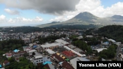 Kompleks Pasar Beriman Tomohon yang berada di tengah kota Tomohon dengan latar gunung Lokon di kejauhan, 10 Maret 2019. (Foto: VOA/Yoanes Litha)