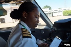In the cockpit, captain Yolanda Ndala-Kaunda goes through the flight instruction pack, at Chileka International Airport in Blantyre, Malawi, March 16, 2017. (L. Masina/VOA)