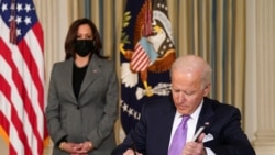 美国副总统哈里斯站在总统拜登身后参加一项行政令签署活动（2021年1月26日）