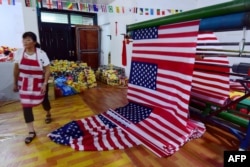 FILE - A Chinese employee walks past newly made U.S. flags at a factory in Fuyang in China's eastern Anhui province, July 13, 2018.