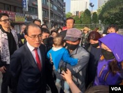 Thae Yong-Ho, a former North Korean diplomat, translates for the family of a nine-year-old girl who was detained in China. (B. Gallo/VOA)