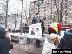 今年3月份的莫斯科反政府抗议集会中，一名女示威者手拿要求抵制索契冬奥会的标语。(美国之音白桦拍摄)