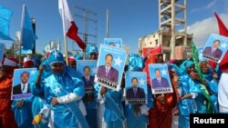 Women carry posters of newly-elected Somalian President Mohamed Abdullahi Farmajo as they celebrate his victory, near the Daljirka Dahson monument in Mogadishu, Somalia, Feb. 11, 2017. Other city residents rallied, pressing for greater political representation.