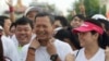 FILE - Lt. Gen. Hun Manet, center, of the Royal Cambodian Armed Forces (RCAF) and the first son of Cambodian Prime Minister Hun Sen, smiles before the start of the international half-marathon in front of Royal Palace in Phnom Penh, Cambodia, Sunday, June 