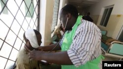A paramedic at the Malindi district hospital attends to a policeman injured when rival communities clashed in Tana River district in the Tana Delta region, Kenya, Jan. 9, 2013. 