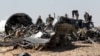 Military investigators from Russia stand near the debris of a Russian airliner at the site of its crash at the Hassana area in Arish city, north Egypt, Nov. 1, 2015. 