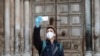 A man takes a selfie in front of the closed Church of the Holy Sepulchre, built in the location where Christians believe Jesus Christ was buried, in Jerusalem, March 25, 2020, as Israel tightens measures to fight the spread of the coronavirus.