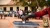 Un homme dépose son bulletin de vote alors que des personnes qui n'ont pas pu voter le premier jour du scrutin font la queue devant les bureaux de vote dans le district de Wakiso, en Ouganda, le 19 février 2016.