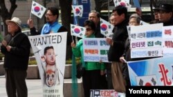 지난 2013년 한국 시민단체 회원들이 서울에서 열린 '어나니머스 대북 4개 항 요구 지지 성명발표 및 이적행위 규탄 수사촉구 기자회견'에서 '우리 민족끼리' 가입자 진상조사 촉구와 관련한 메시지가 담긴 손팻말을 들고 있다. (자료사진)