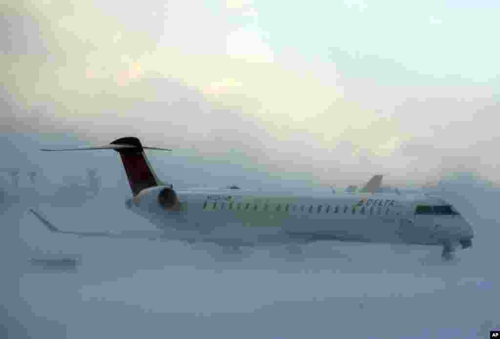 A plane negotiates its way through the snow at the Buffalo Niagara International Airport in Buffalo, N.Y., Nov. 18, 2014.