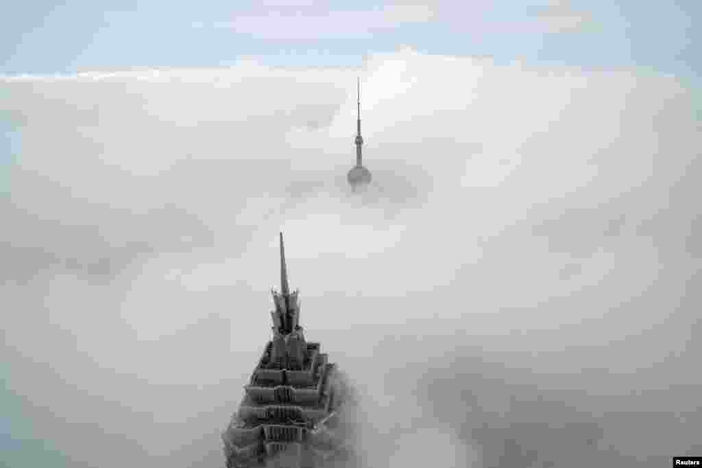 អគារ​ខ្ពស់​កប់​ពពក​ពីរ​ គឺ Oriental Pearl Tower និង​ Jin Mao Tower (ខាងមុខ) ត្រូវ​បាន​មើល​ឃើញ​ពីមជ្ឈមណ្ឌល​ហិរញ្ញវត្ថុ​ពិភពលោក​សៀងហៃ​ក្នុង​សង្កាត់ Pudong ទីក្រុង Shanghai ប្រទេសចិន។