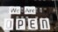 USA, Columbus, Ohio, A "we are open" sign is placed in the window of a restaurant as Ohio